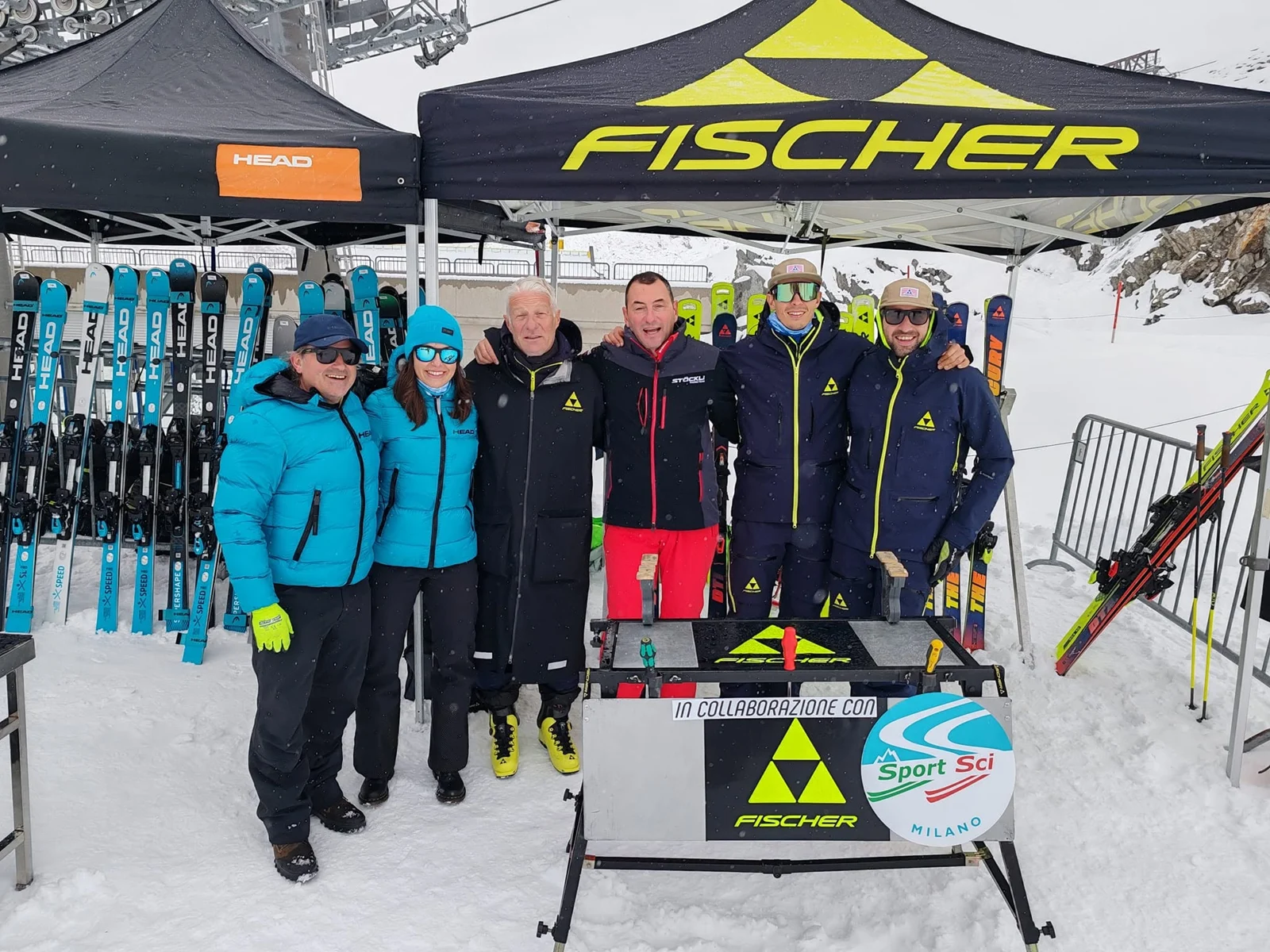 Gruppo di sciatori davanti agli stand e agli sci sulla neve